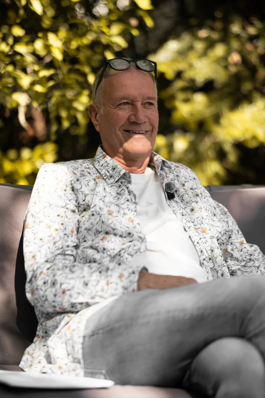 Thomas Schimmeck – lachend auf dem Sofa im Garten, Brille auf dem Kopf